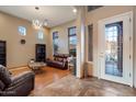 Bright living room features a stylish chandelier, hardwood floors, and a beautiful front door at 35206 N 27Th Ave, Phoenix, AZ 85086