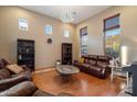 Spacious living room with large windows, wood floors, and a leather sofa, creating a cozy atmosphere at 35206 N 27Th Ave, Phoenix, AZ 85086