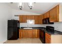 Functional kitchen equipped with modern black appliances and wood cabinets at 3646 N 67Th Ave # 20, Phoenix, AZ 85033
