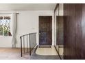 Inviting entryway showcasing a dark wooden door, mirrored wall accents, and decorative window with ample natural light at 3741 W Davidson Ln, Phoenix, AZ 85051
