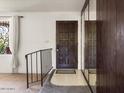 Foyer of home with stairway, dark front door, mirrored wall and decorative window at 3741 W Davidson Ln, Phoenix, AZ 85051