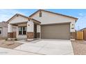 Charming single-story home featuring a two-car garage, covered porch, and low maintenance desert landscaping at 42405 W Peters Dr, Maricopa, AZ 85138