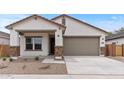 Charming single-story home featuring a two-car garage, covered porch, and low maintenance desert landscaping at 42405 W Peters Dr, Maricopa, AZ 85138