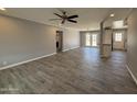 Spacious living room featuring gray walls, wood-look tile flooring, a ceiling fan, and access to the backyard through French doors at 5815 N 21St Ave, Phoenix, AZ 85015