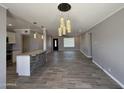 Open-concept living area with modern light fixtures, gray flooring, and a kitchen island with granite countertops at 5815 N 21St Ave, Phoenix, AZ 85015