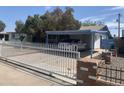 Charming single-story home with a white fence, carport, and mature trees at 5833 W Rosewood Ln, Phoenix, AZ 85031