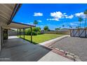 Large backyard with a covered patio, lush green lawn, and low-maintenance landscaping at 6160 E Inglewood St, Mesa, AZ 85205