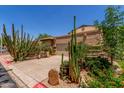 Beige home with desert landscaping featuring a two-car garage and cacti, showcasing southwestern charm and curb appeal at 630 E Jensen St # 102, Mesa, AZ 85203