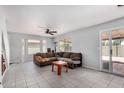 Spacious living room with neutral tile flooring, a ceiling fan, and natural light at 630 E Jensen St # 102, Mesa, AZ 85203