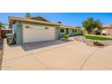 Spacious driveway leading to a two-car garage, complemented by rock garden and artificial grass at 810 W Villa Maria Dr, Phoenix, AZ 85023