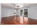 Bright living room featuring hardwood floors, ceiling fan, and sliding glass doors to the backyard at 810 W Villa Maria Dr, Phoenix, AZ 85023