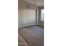 Cozy living area with soft carpeting and a large window offering natural light at 8582 W Rue De Lamour --, Peoria, AZ 85381