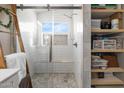 Modern bathroom featuring a glass-enclosed shower with bench seating and tiled walls and storage shelves at 8948 W Fargo Dr, Peoria, AZ 85382