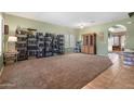 Spacious living room featuring neutral paint, carpet, and tile flooring with ample natural light at 13313 W Indianola Ave, Litchfield Park, AZ 85340