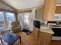 Bright living room leading to sliding door, featuring wood floors and a comfortable recliner at 1426 S Havasupai Dr, Apache Junction, AZ 85119