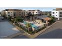 Stunning aerial view of community pool with lounge chairs and lush landscaping between modern apartment buildings at 19360 N 73Rd St # 1066, Scottsdale, AZ 85255