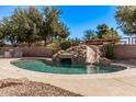Backyard swimming pool with custom rock waterfall and slide, perfect for outdoor entertaining and relaxation at 19903 S 187Th Dr, Queen Creek, AZ 85142