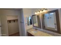 Well-lit bathroom featuring dual mirrors, granite vanity, and an enclosed toilet area at 23929 W Twilight Trl, Buckeye, AZ 85326