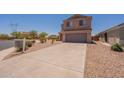 Two-story home featuring a neutral stucco exterior, gray garage door, and low-maintenance landscaping at 23929 W Twilight Trl, Buckeye, AZ 85326