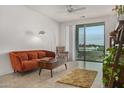 Modern living room featuring an orange sofa, coffee table with chess, and access to a balcony at 2511 W Queen Creek Rd # 378, Chandler, AZ 85248