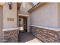 Close up of the front door featuring a wrought iron security door and stone accents at 2543 W Rabjohn Rd, Phoenix, AZ 85085