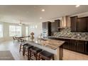 Open-concept kitchen featuring dark cabinets, granite countertops, and a center island with seating at 2543 W Rabjohn Rd, Phoenix, AZ 85085
