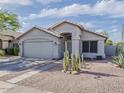 Charming single-story home featuring desert landscaping, a two-car garage, and covered front entry at 2550 E Caballero St, Mesa, AZ 85213