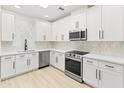 Bright, updated kitchen featuring white cabinets, stainless steel appliances, marble backsplash, and light wood flooring at 3221 N 37Th St # 26, Phoenix, AZ 85018
