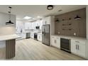 Bright kitchen features stainless steel appliances, island with seating and wood panel accent wall with shelving at 3221 N 37Th St # 26, Phoenix, AZ 85018