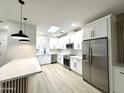 Bright kitchen features stainless steel appliances, island with seating and white cabinetry at 3221 N 37Th St # 26, Phoenix, AZ 85018