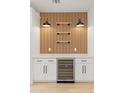 Kitchen beverage station features a beverage cooler, white cabinets, countertop, vertical wood paneling, and stylish wall-mounted lighting at 3221 N 37Th St # 26, Phoenix, AZ 85018