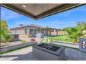 Beautiful outdoor space featuring a covered patio, fire pit, and putting green at 3498 E Ravenswood Dr, Gilbert, AZ 85298