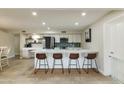 Bright kitchen with a central island and seating, stainless appliances, and neutral tones at 3824 W Carol Ave, Phoenix, AZ 85051