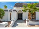 Inviting entrance with desert landscaping and a stylish, arched doorway leading to custom metal doors at 3951 E Sequoia Trl, Phoenix, AZ 85044
