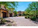 Elegant stucco home with a charming stone driveway and lush landscaping at 40853 N 94Th St, Scottsdale, AZ 85262
