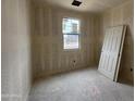 Bedroom with a bright window, drywall, and concrete floors, ready for finishing at 46886 W Coe St, Maricopa, AZ 85139