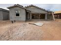 New construction home showing stucco work, scaffolding, and a dirt yard at 46886 W Coe St, Maricopa, AZ 85139