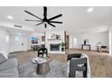 Open living room with a painted fireplace, beam ceiling fan, and wood-look flooring at 6038 E Hobart St, Mesa, AZ 85205