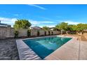 Sparkling in-ground swimming pool in a fenced backyard with mature trees at 6038 E Hobart St, Mesa, AZ 85205