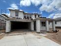 New home in construction phase with open garage, windows prepped for install and blue sky background at 7401 W Buckhorn Trl, Peoria, AZ 85383