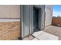 Close-up of the front door with gray siding and brick accents at 7437 S 75Th Dr, Laveen, AZ 85339