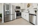 Modern kitchen with stainless steel appliances, white cabinets, countertops, and tile flooring at 7437 S 75Th Dr, Laveen, AZ 85339