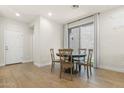 Bright dining room with a round wooden table set, wood-look tile floors, and a sliding glass door to the backyard at 8343 E Irwin Ave, Mesa, AZ 85209
