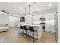 Open kitchen features white cabinets, stainless steel appliances, pendant lighting and an island with bar stool seating at 8343 E Irwin Ave, Mesa, AZ 85209