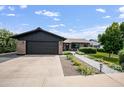 Beautiful home featuring a detached garage with a black door, manicured lawn, and brick exterior at 8425 E Bonnie Rose Ave, Scottsdale, AZ 85250