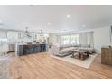 Bright open floorplan with hardwood floors, modern furnishings, and a kitchen island with barstool seating at 8455 E Orange Blossom Ln, Scottsdale, AZ 85250
