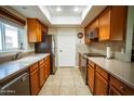 Galley kitchen with stainless steel appliances, tiled flooring, and neutral countertops at 919 W Lodge Dr, Tempe, AZ 85283