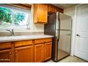 Kitchen area showcasing stainless steel refrigerator, ample cabinet space, and bright window at 919 W Lodge Dr, Tempe, AZ 85283
