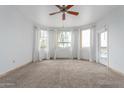 Bright living room with neutral carpet, ceiling fan, and a door that leads to a balcony with great views at 9820 N Central Ave # 224, Phoenix, AZ 85020