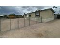 Tan home with chain link fence surrounding a gravel yard with front door at 10231 E Illini St, Mesa, AZ 85208